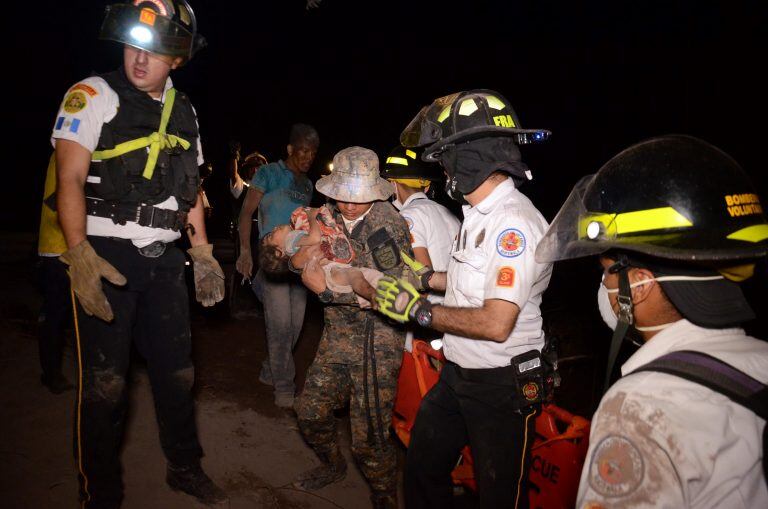 Un bebé es rescatado de las cenizas tras la erupción del Volcán de Fuego en Guatemala. / AFP PHOTO / NOE PEREZ