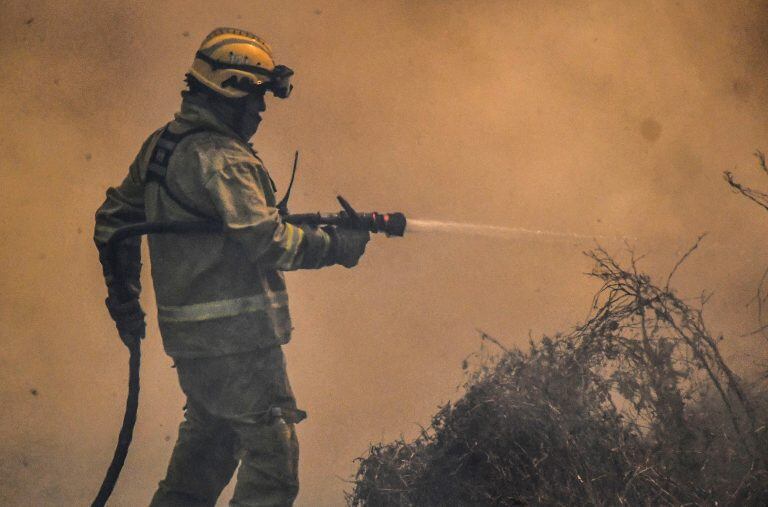 23 September 2020, Argentina, Cordoba: A firefighter douses flames of a wildfire near the Argentine National Observatory. Photo: Irma Montiel/telam/dpa