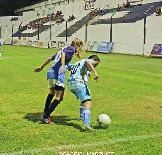 Cintia Rojo, volante de Racing, protege la pelota de la marca de una rival en cancha de Juniors