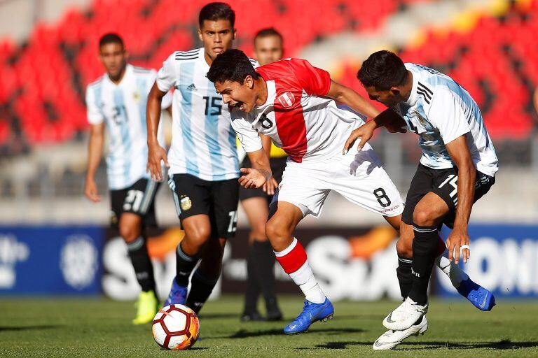 El jugador de la selección peruana de fútbol Jairo Concha,  disputa el balón con el seleccionado de Argentina Facundo Medina (d) este sábado, durante un partido del campeonato sudamericano Sub20, en el estadio Fiscal de Talca (EFE).