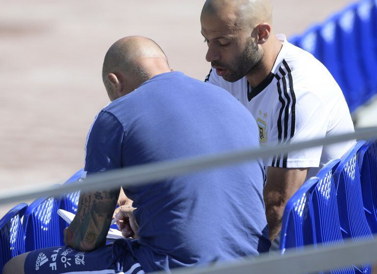 Javier Mascherano le da algunos consejos a Jorge Sampaoli durante la práctica argentina de este lunes 25 de junio de 2018 en Bronnitsy, Rusia. AFP PHOTO / JUAN MABROMATA