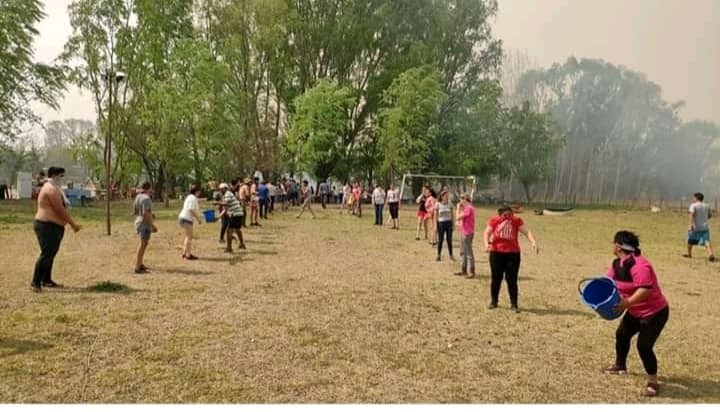 En Mina Clavero se formó un corredor humano de acarreo de agua para combatir los incendios. (Belen Intima)