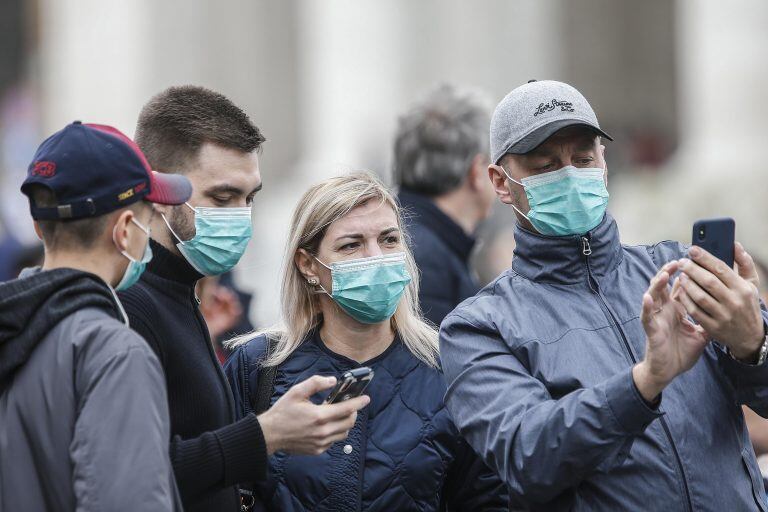 Varios asistentes llevan mascarillas para protegerse del coronavirus mientras asisten a la oración del Angelus, oficiada por el papa Francisco, en la plaza de San Pedro del Vaticano  EFE/ Fabio Frustaci