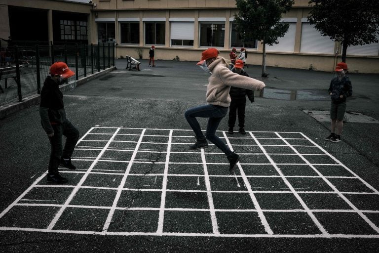 Los niños usan máscaras protectoras para jugar en el patio. (Foto: AFP)