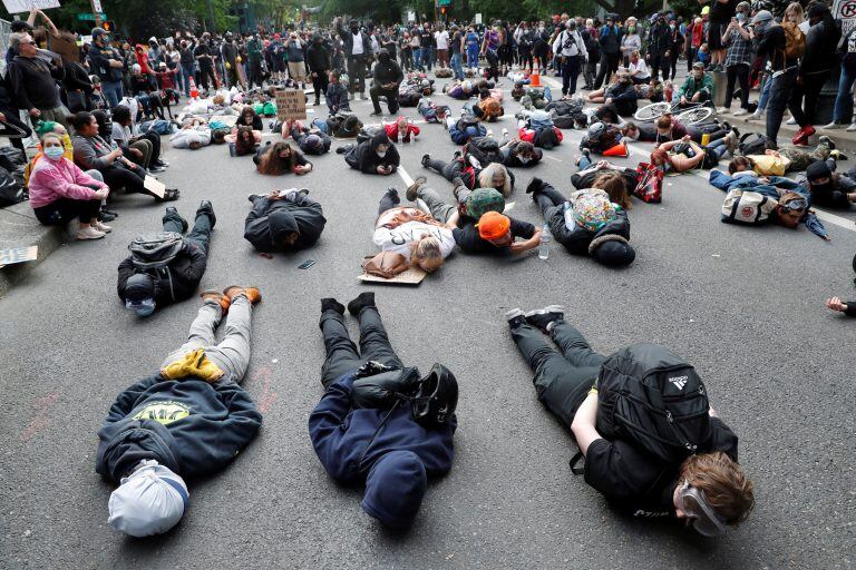 Manifestantes en Oregon imitan la pose en la que fue asesinado George Floyd, al grito de "No puedo respirar" (Reuter)