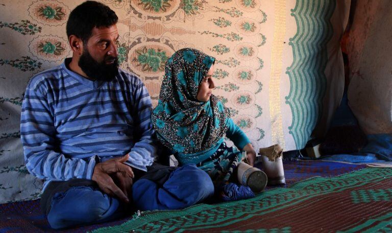 Maya y su padre dentro de la carpa donde viven en un campo de refugiados. AP.