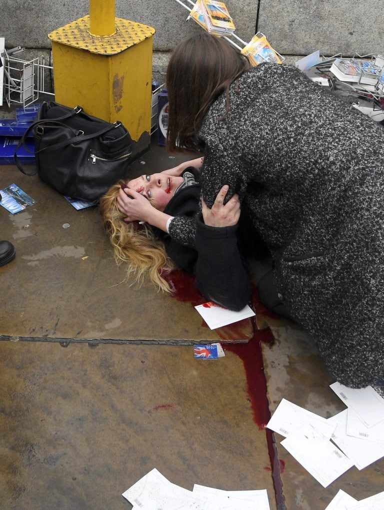 An injured woman is assisted after an incident on Westminster Bridge in London, Britain March 22, 2017.  REUTERS/Toby Melville