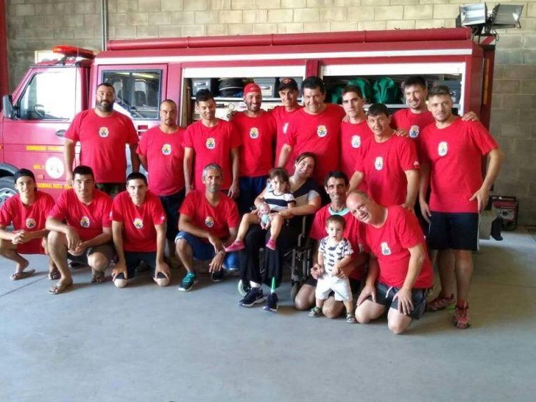 Luciana Fauguel  y con los bomberos que la rescataron.