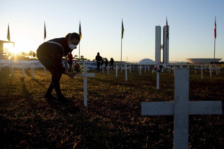 Varias personas participan en las instalación de centenares de cruces como homenaje a las víctimas de Covid-19 en la Explanada de los Ministerios de Brasil (Foto: EFE/ Myke Sena)