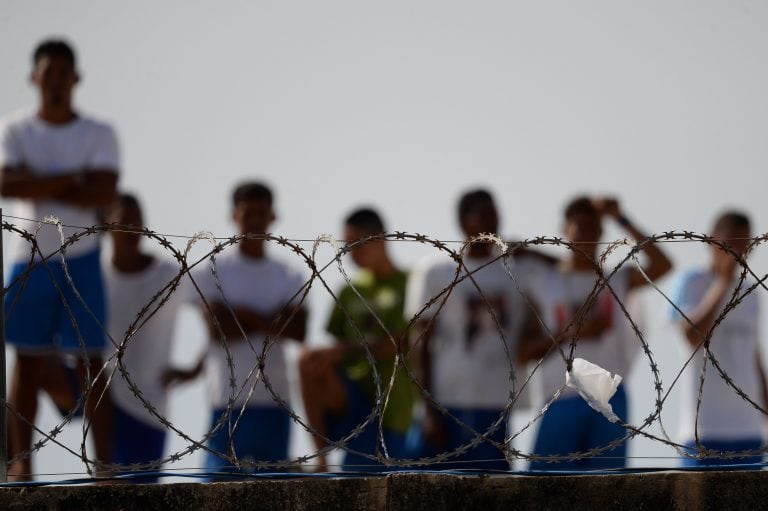 (FILES) This file photo taken on January 20, 2017 shows inmates watching as injured prisoners are removed to receive medical care the day after a battle between gangs in the Alcacuz Penitentiary Center, where inmates remain armed and out of control, near Natal in Rio Grande do Norte, Brazil.
Brazil has the third largest prison population in the world, with 726,712 inmates according to the latest official data of June 2016. With outdated and overcrowded buildings, low budget and half of the inmates in pre-trial detention, the State is losing control in the hands of drug trafficking gangs. / AFP PHOTO / ANDRESSA ANHOLETE / TO GO WITH AFP STORY by Damian WROCLAVSKY brasil Rio Grande do Norte  brasil motin en carcel Alcacuz motines violencia carceles prisiones