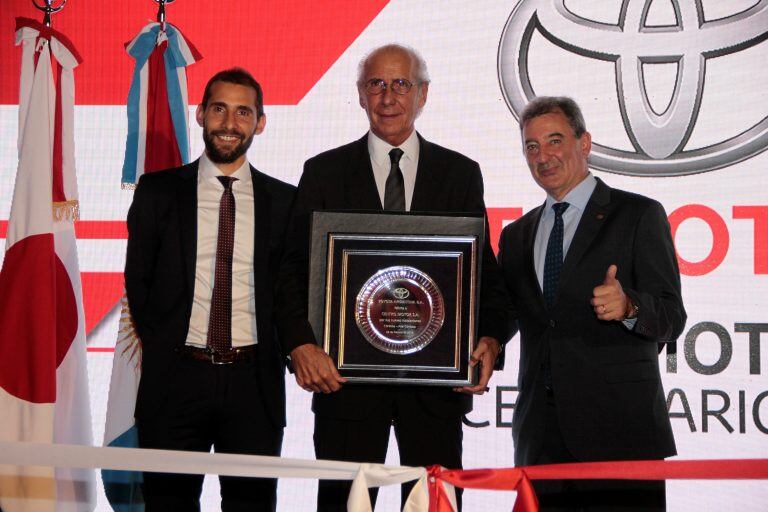 Darío Ramonda (en el medio) recibe de Daniel Herrero (presidente de Toyota Argentina, a la derecha) un reconocimiento por la inauguración de las nuevas instalaciones de Centro Motor en Córdoba. Los acompaña Darío José Ramonda, gerente general de la firma cordobesa.