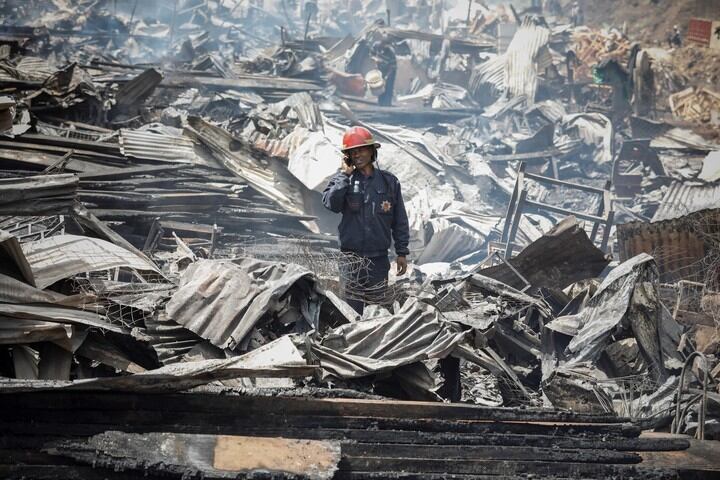 Un bombero se comunica dentro de lo que quedó del mercado