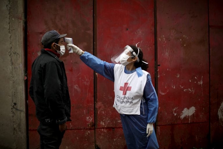 Un voluntario de La Cruz Roja toma la temperatura a un hombre(AP Photo/Natacha Pisarenko)