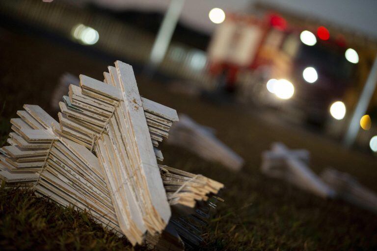 Varias personas participan en las instalación de centenares de cruces como homenaje a las víctimas de Covid-19 en la Explanada de los Ministerios de Brasil (Foto: EFE/ Myke Sena)