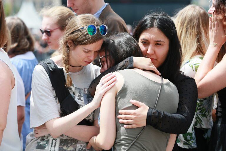 Compañeras de la estudiante de 22 años asesinada ayer guardan un minuto de silencio por las víctimas del tiroteo de ayer ante el Café 'Les Augustins', de Lieja, Bélgica. EFE/ Stephanie Lecocq