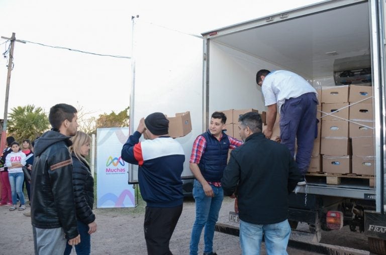 Voluntarios de la Fundación "Muchas" llevando las cajas con la donación para los merenderos de Barranqueras.