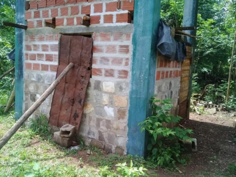 La ventana tiene barrotes de madera y la puerta está apoyada por un poste de madera para que no escape.