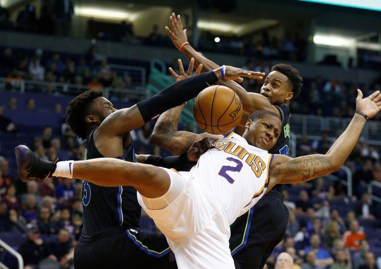 Phoenix Suns guard Isaiah Canaan (2) is fouled by Dallas Mavericks guards Wesley Matthews, left, and Yogi Ferrell, right, during the first half of an NBA basketball game Wednesday, Jan. 31, 2018, in Phoenix. (AP Photo/Ross D. Franklin)