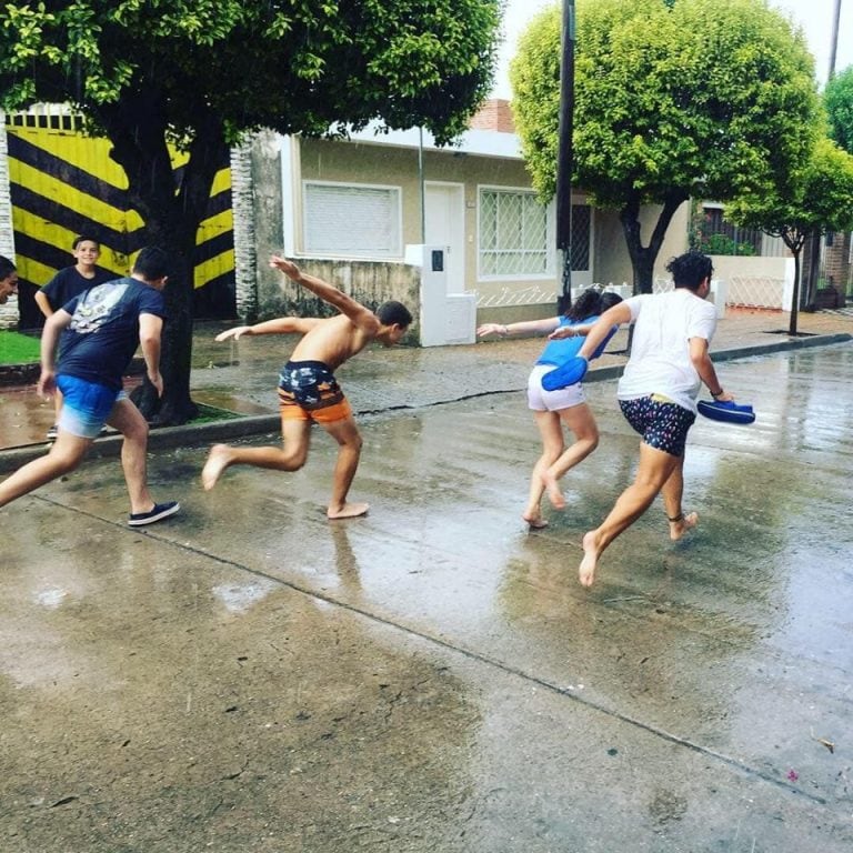 Las fotos de los adolescentes cordobeses jugando bajo la lluvia fueron tomadas por Juan Pablo Rodríguez, en barrio Los Naranjos.