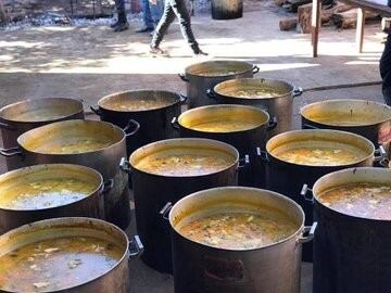 Despliegue solidario realizado por la organización Indu Solidaria y los Bomberos en 23 ollas con locro repartido en los barrios de Posadas. (Policía)