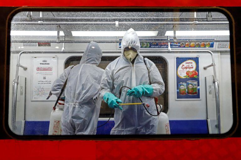 Personal médico desinfecta un vagón del metro en Teherán (Irán).