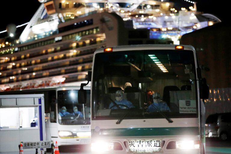 Colectivos trasladan a pasajeros israelíes que estaban en el crucero ((AP Photo/Eugene Hoshiko)