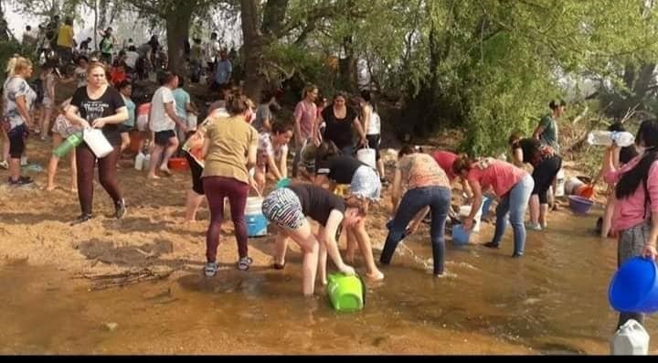 En Mina Clavero se formó un corredor humano de acarreo de agua para combatir los incendios. (Belen Intima)