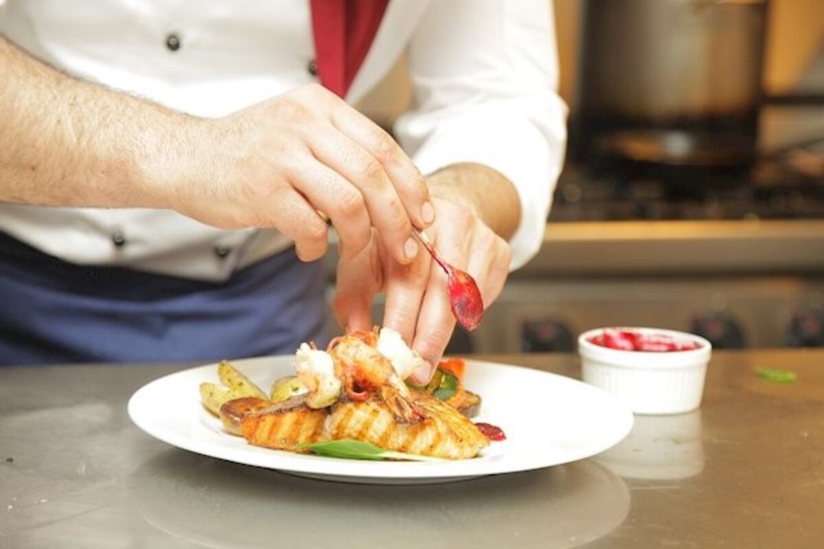 Un chef cocinó sin barbijo y lo agarraron escupiendo un plato