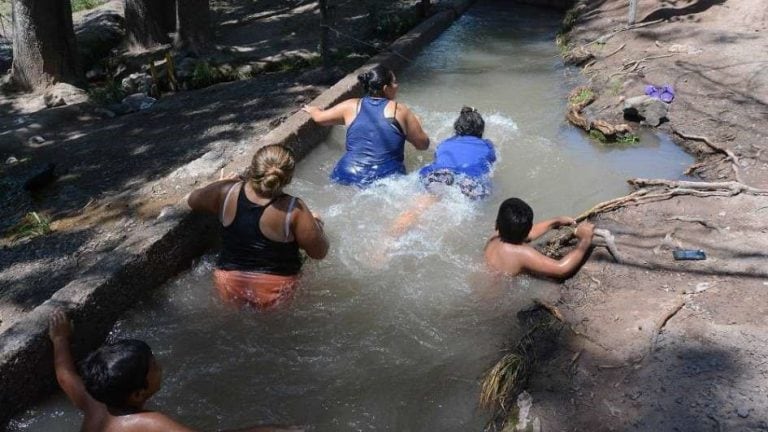 Personas refrescándose en zanjones.