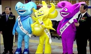 Un entrenador, Ato (amarillo), y dos futbolistas: Kaz (violeta) y Nik (celeste), todos ellos hechos de energía. Los alienígenas conforman el equipo de Atmoball (un deporte ficticio similar al fútbol). Las mascotas del 2002, un bodrio.