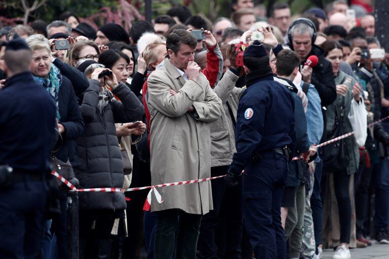 People look at Notre-Dame Cathedral after a massive fire devastated large parts of the gothic gem in Paris, France, April 16, 2019.