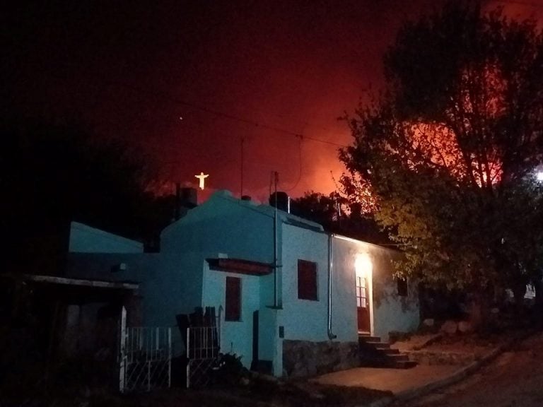 Cristo Redentor de La Cumbre iluminado por las llamas.