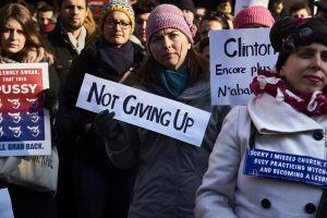 A woman holds a placard reading "Not giving up" during a rally in solidarity with supporters of the Women's March taking place in Washington and many other cities on January 21, 2017 in Lyon, southeastern France, one day after the inauguration of the US P