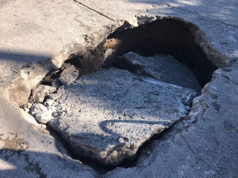 La calle se hundió y su auto quedó atrapado.