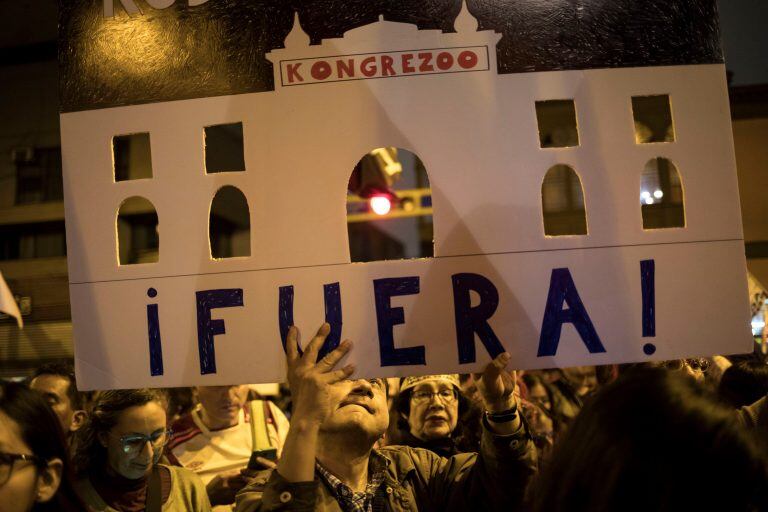 Un partidario del presidente peruano Martin Vizcarra sostiene un recorte del edificio del Congreso. Crédito: AP Photo/Rodrigo Abd.