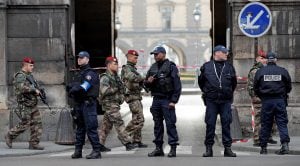 Police officers and soldiers patrol the area near the Louvre museum near where a soldier opened fire after he was attacked in Paris, Friday, Feb. 3, 2017. Police say the soldier opened fire outside the Louvre Museum after he was attacked by someone, and t