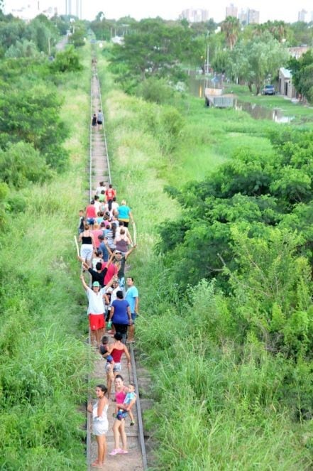 Un grupo de personas caminaban por las vías luego de cortar durante horas el puente alto nivel en la Ruta N° 11.