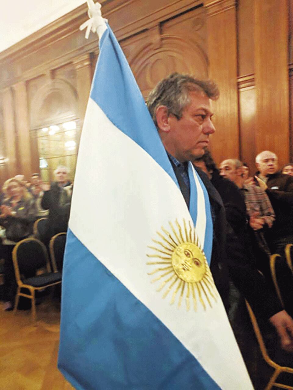 Fabián sosteniendo la bandera nacional en un acto en conmemoración a los ex combatientes.