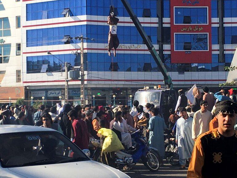 MATERIAL SENSIBLE. El cadáver de un hombre colgado por los talibanes en una grúa en la plaza principal de Herat, Afganistán.