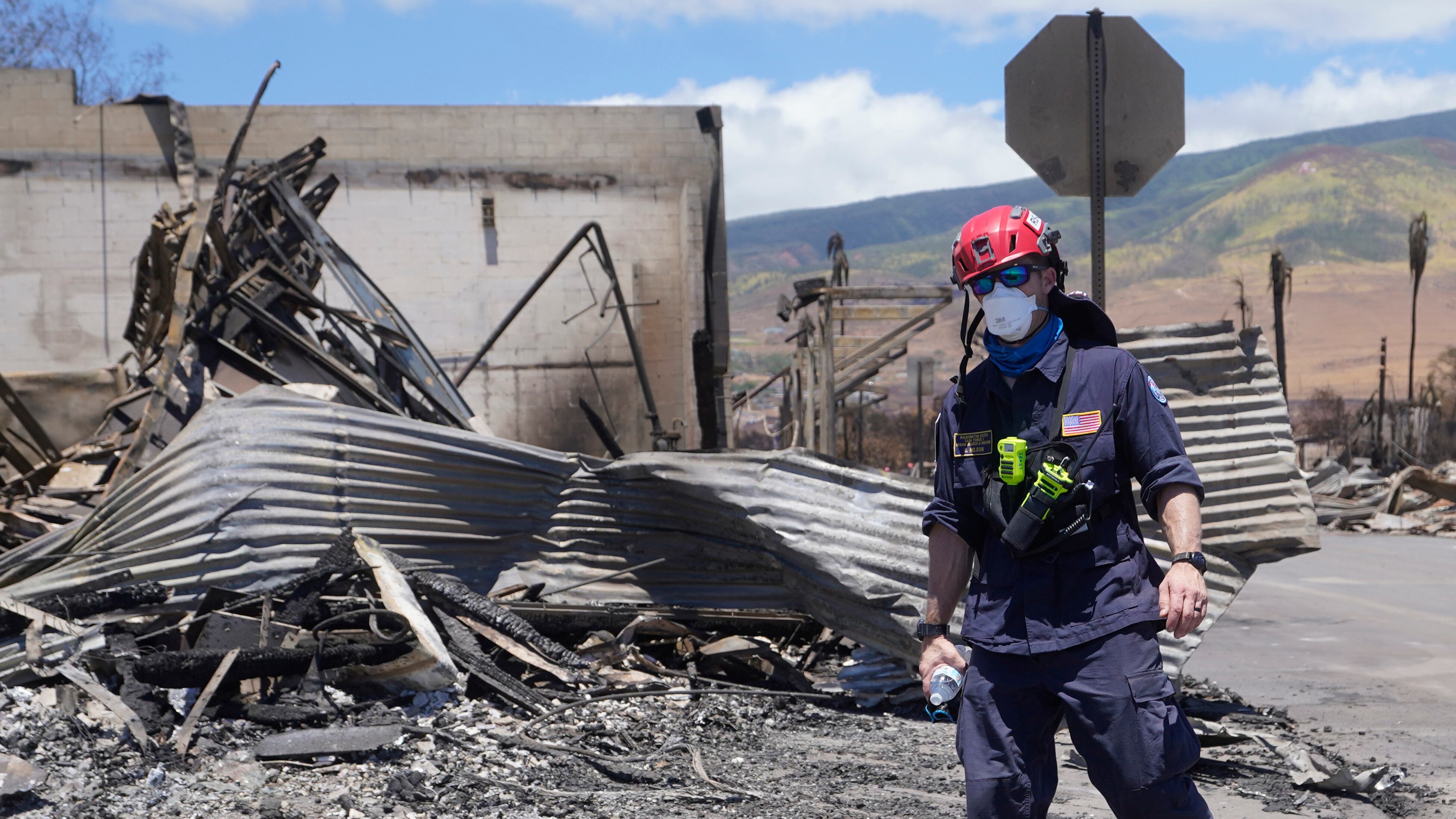 Un trabajador de búsqueda y rescate camina por una calle el sábado 12 de agosto de 2023 en Lahaina, Hawai, tras incendios forestales que causaron graves daños. (AP Foto/Rick Bowmer)