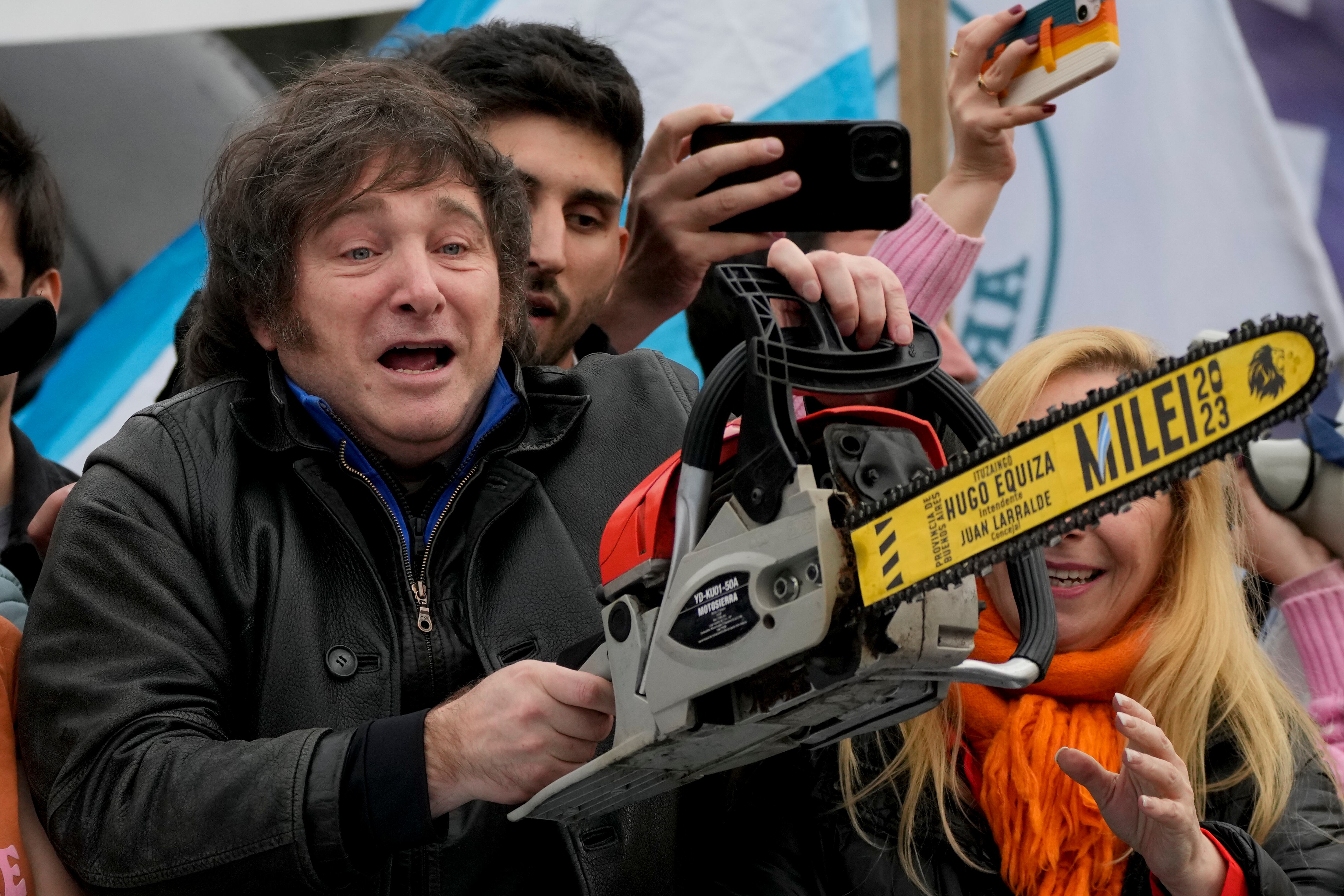 El aspirante presidencial Javier Milei, de la coalición La Libertad Avanza, carga una motosierra durante un mitin de campaña en La Plata, Argentina, el martes 12 de septiembre de 2023. 