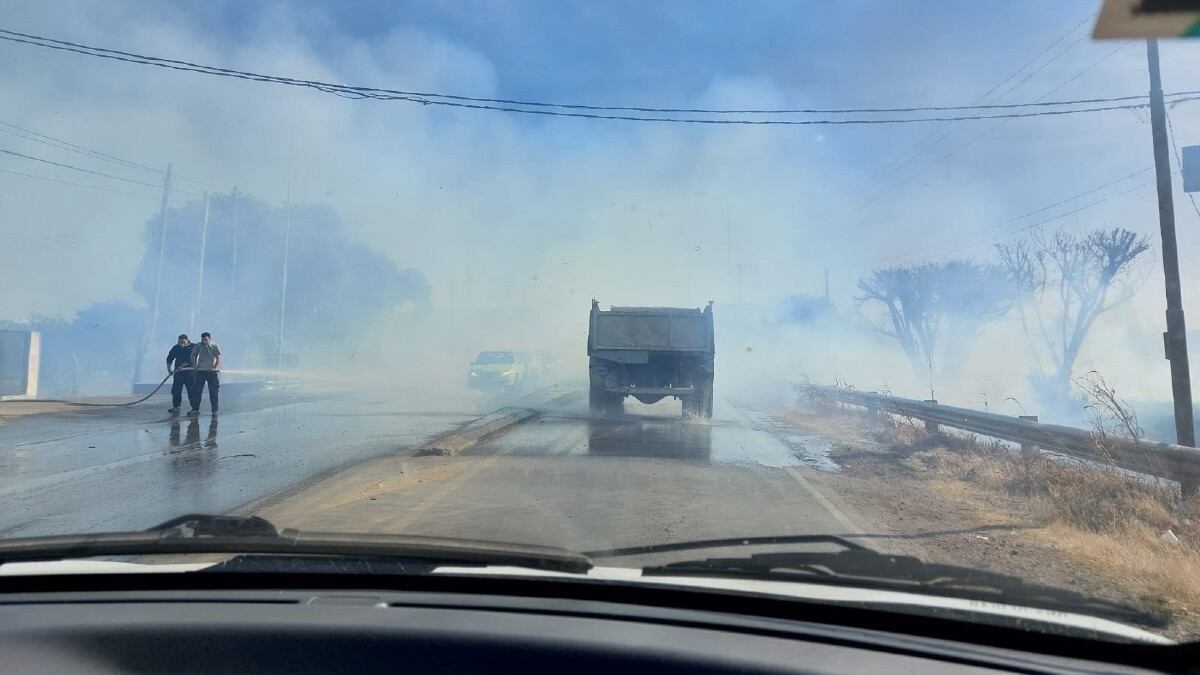 Bomberos debieron regar la calle para que el fuego no llegue a la estación de servicio.