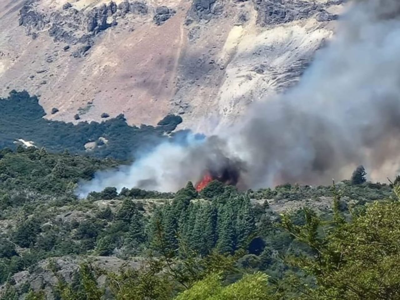 Brigadistas trabajan para apagar el fuego en conjunto con medio aéreos.