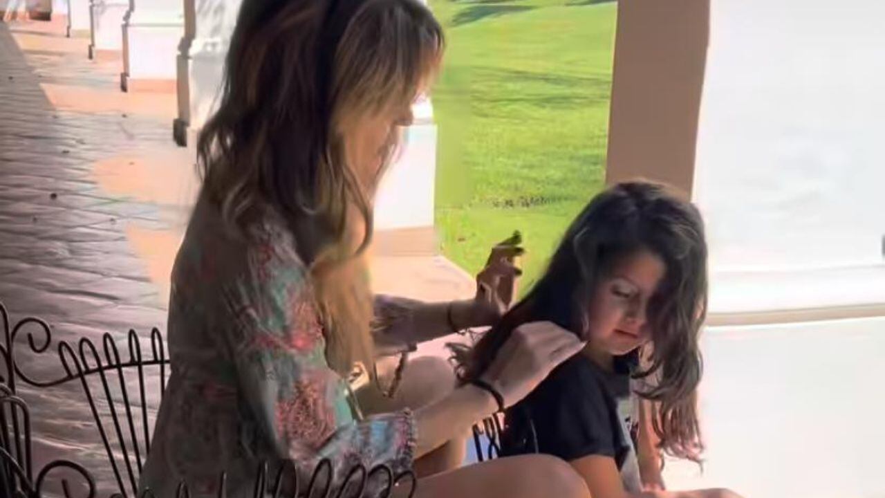 Isabel Macedo con su hija mayor mientras le corta el cabello.