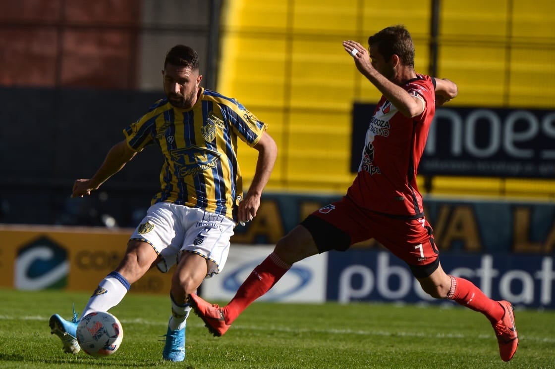 El defensor de Atlanta, Alan Jerez despeja ante la presión del delantero de Deportivo Maipú, Diego Tonetto, en el partido disputado por la Primera Nacional.