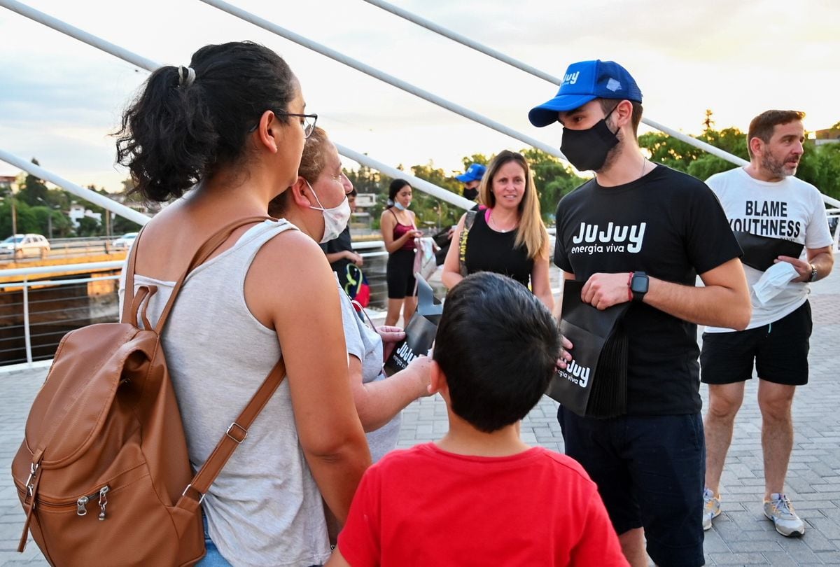 Paseantes en Villa Carlos Paz reciben información sobre la oferta turística de Jujuy.