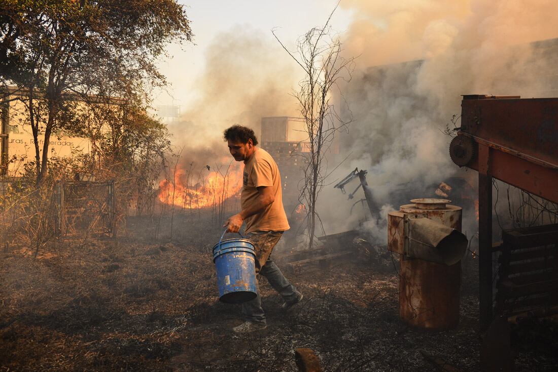 Incendio en una vivienda en Chacras de la Merced. Vecinos combaten las llamas que llegaron a una casa. (José Gabriel Hernández)