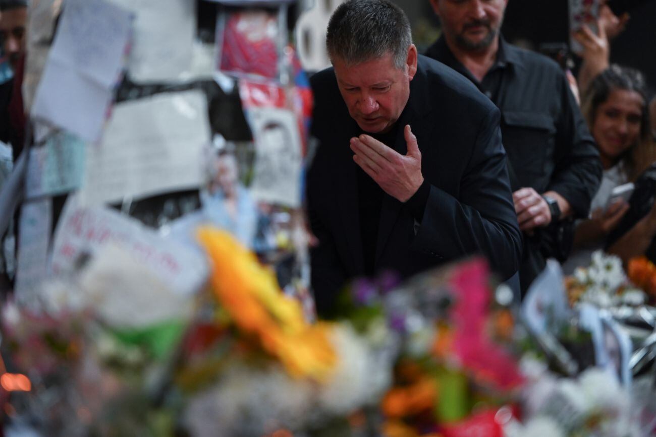 Geoff Payne, padre de Liam, en el santuario que los fanáticos montaron en la vereda en la que falleció (AP).