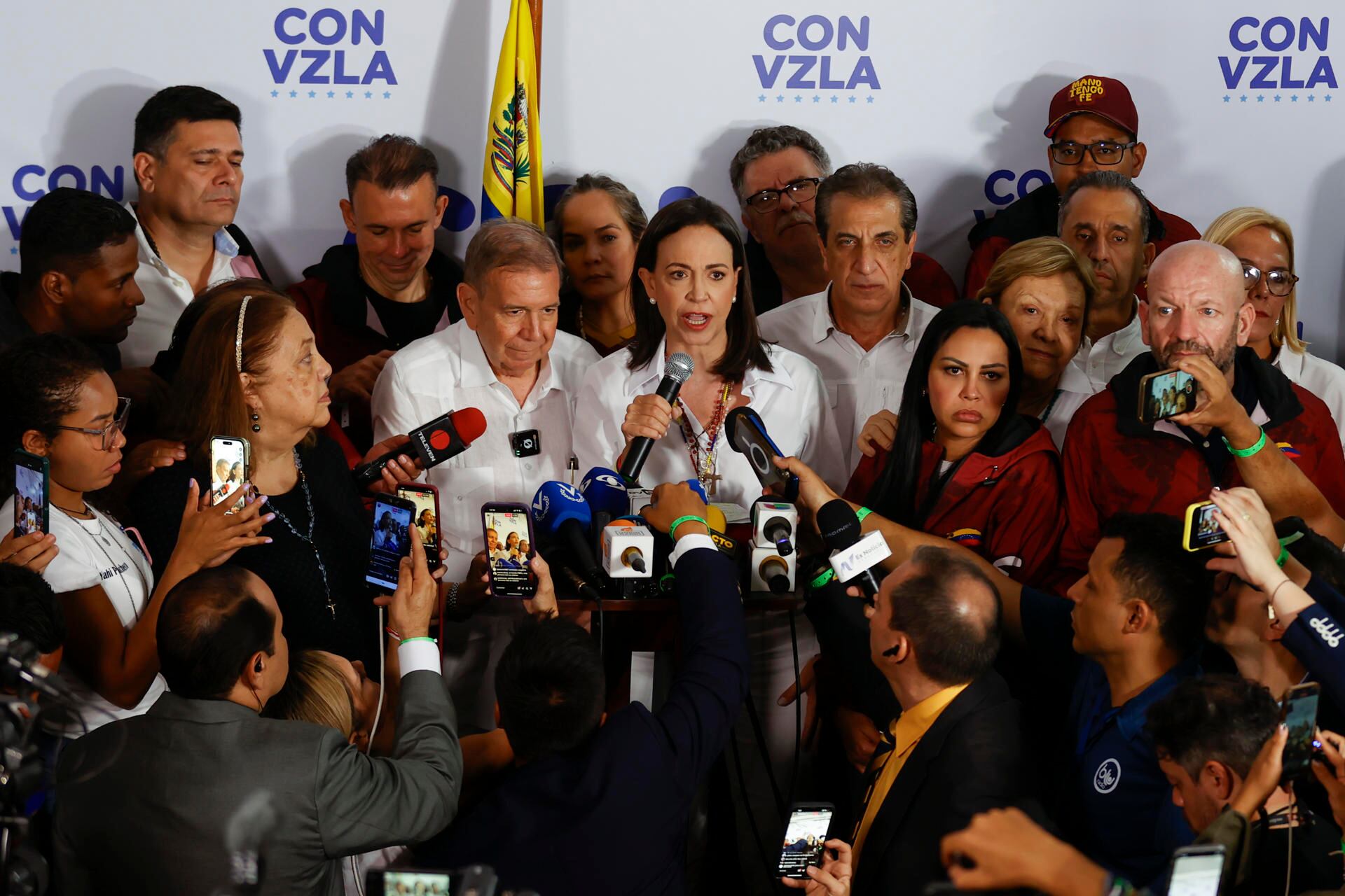 El candidato a la presidencia de Venezuela, Edmudo González Urrutia (c-i), y la líder opositora venezolana, María Corina Machado (c-d), dan declaraciones tras conocer los resultados de las elecciones presidenciales este lunes, en Caracas (Venezuela). Machado dijo que el 