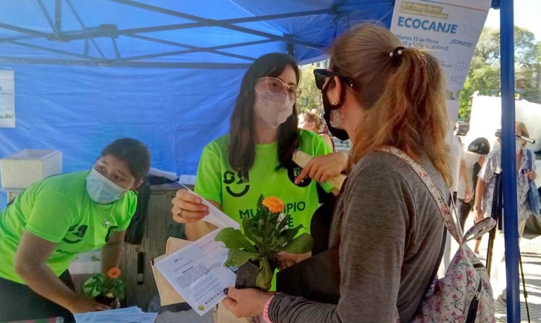 Canjeaban botellas de plástico por bolsas y flores.